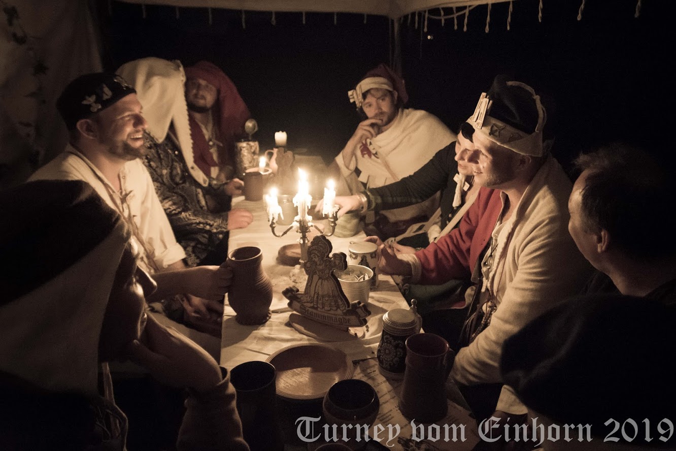 mittelalterliche Taverne, trinkende Menschen, Stammtischschild im Vordergrund - Illustration für die Taverne "Der tapfere Knecht" auf dem Turney vom Einhorn
